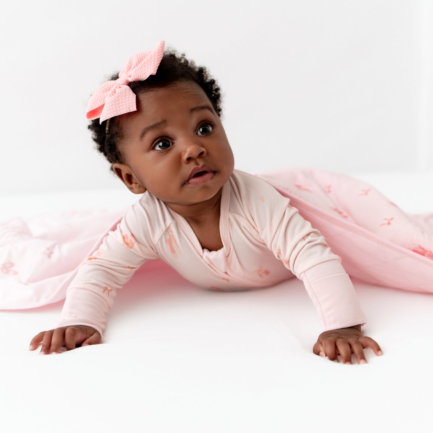 Baby in a pink ballerina print footie with matching ballerina blanket